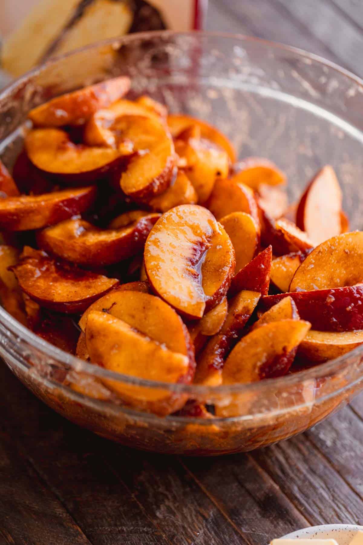 Peaches tossed in a bowl with sugars, spices, corn starch and vanilla. 