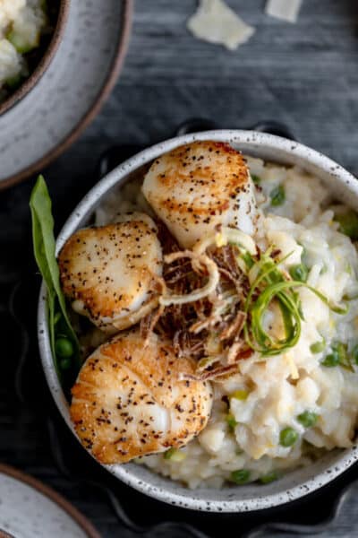 Mushroom and asparagus risotto with scallops in a bowl.