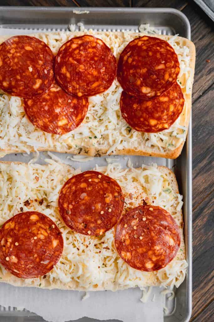 Layered pepperoni and cheese on top of garlic bread.