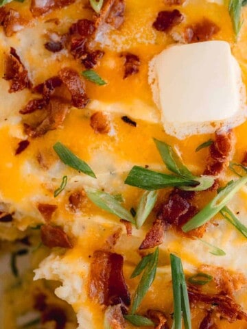 Loaded potato casserole topped with cheddar cheese, butter, bacon and green onion.