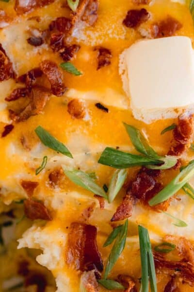 Loaded potato casserole topped with cheddar cheese, butter, bacon and green onion.