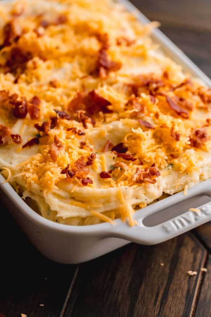 Loaded mashed potato casserole topped with cheddar and bacon.