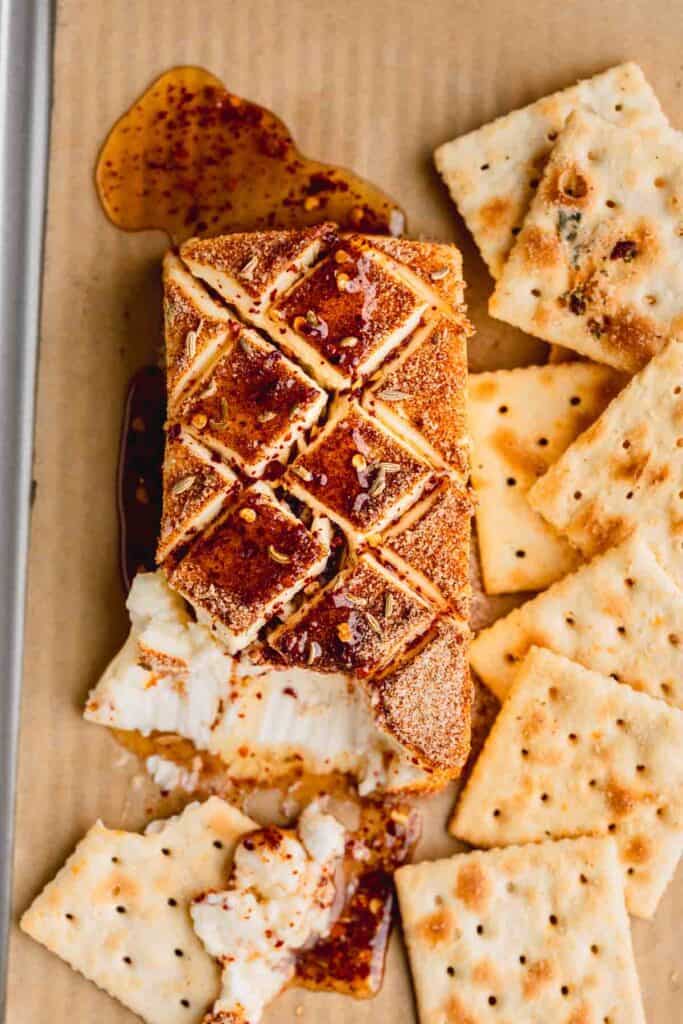 Smoked Cream Cheese with hot honey and crackers on a tray.