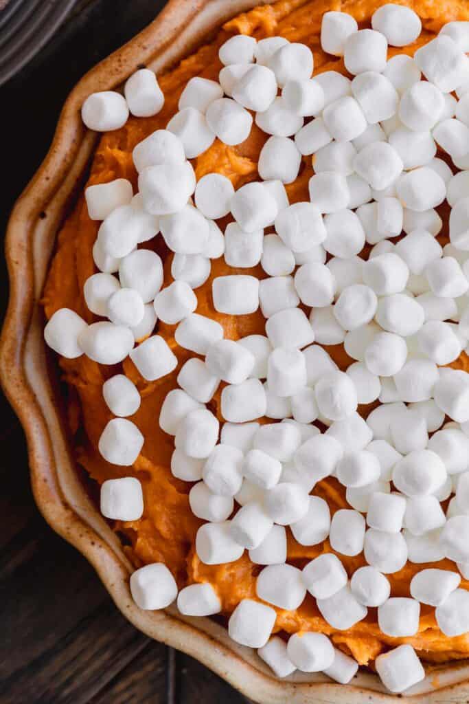 Marshmallows on top of sweet potato pudding before being baked.