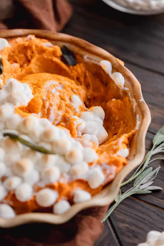 Sweet potato pudding topped with baked marshmallows and sage.
