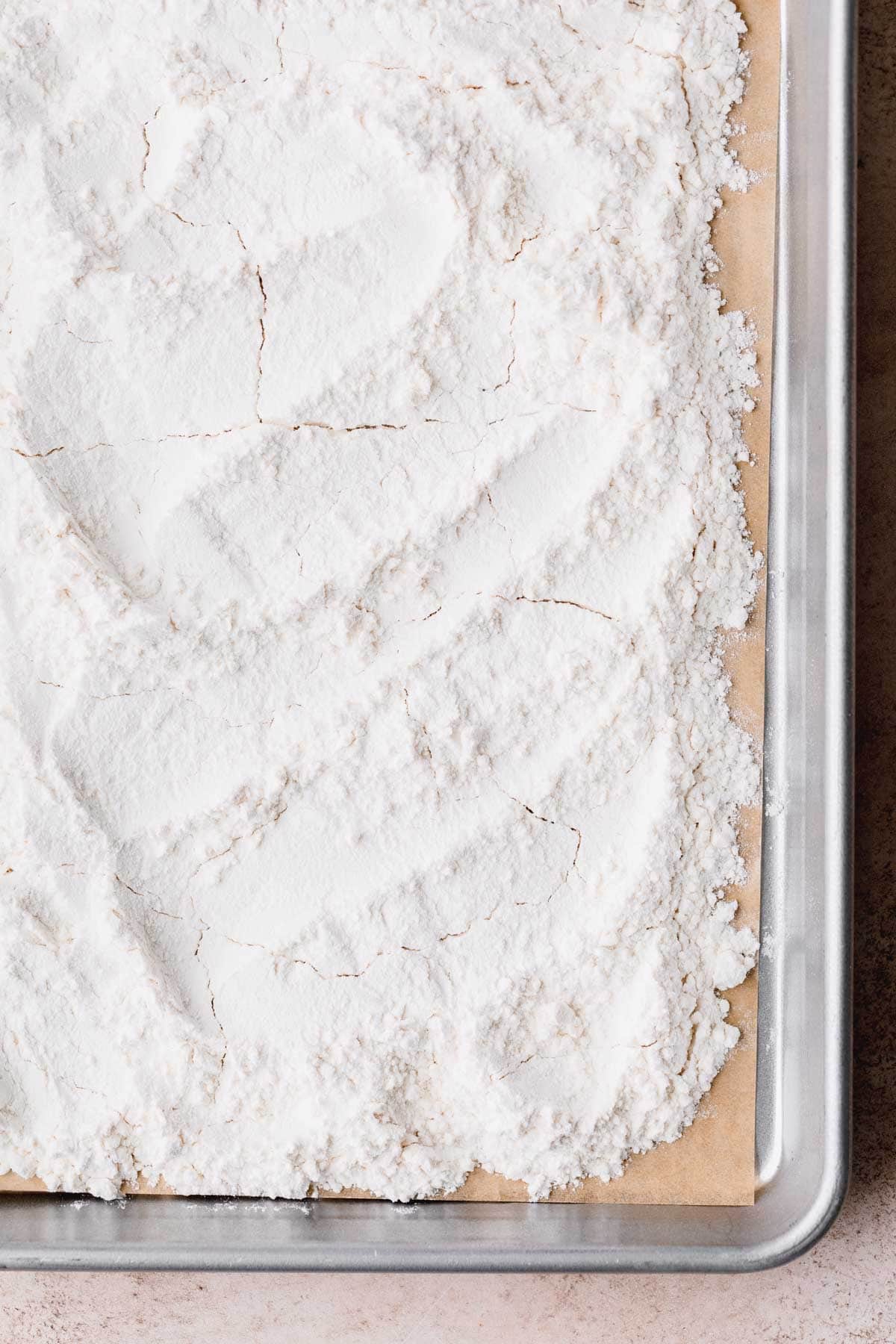 Flour spread out on a baking sheet, ready to be baked.