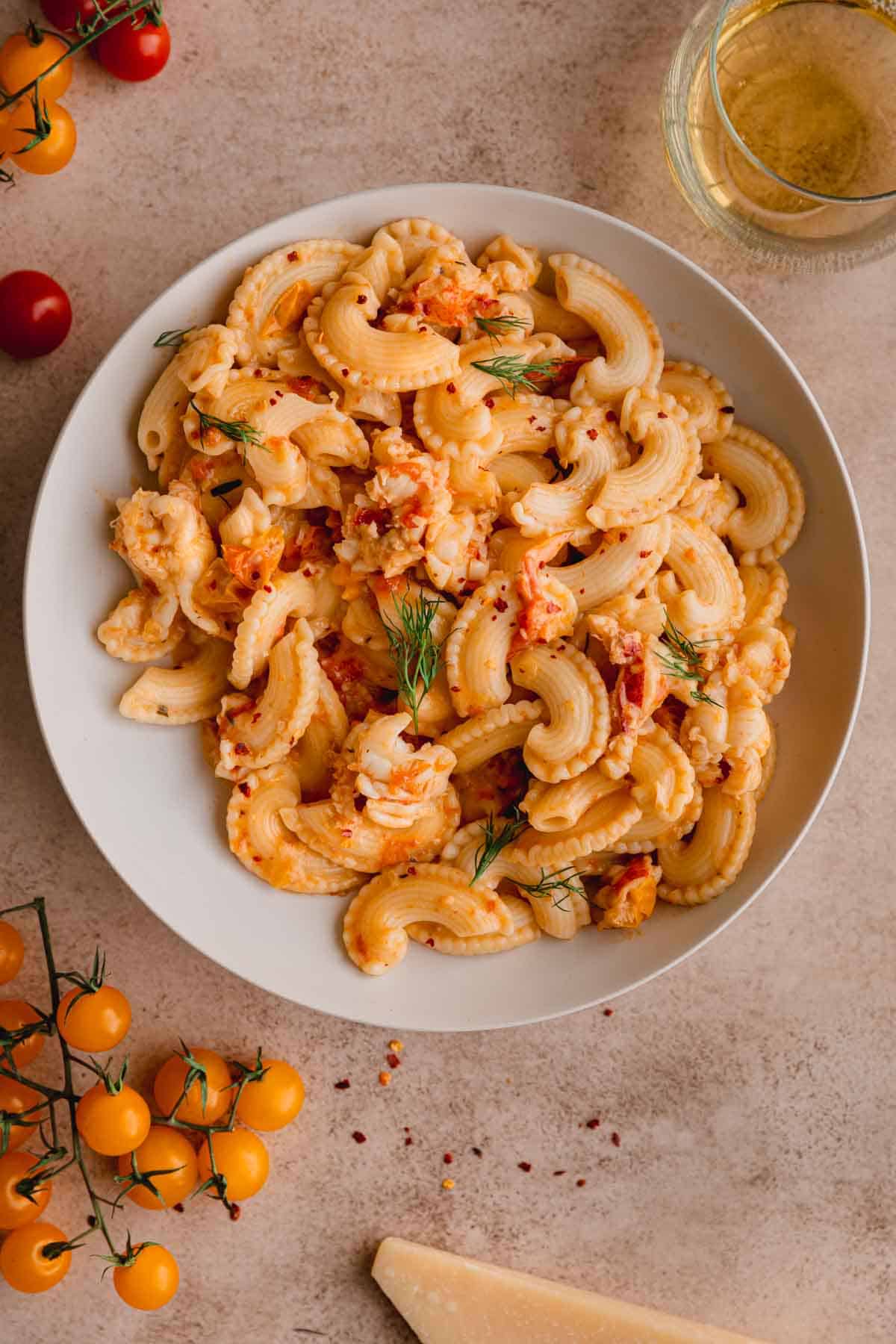 Creamy Lobster Pasta recipe in a large bowl with chunks of lobster, crushed red pepper and fresh dill.