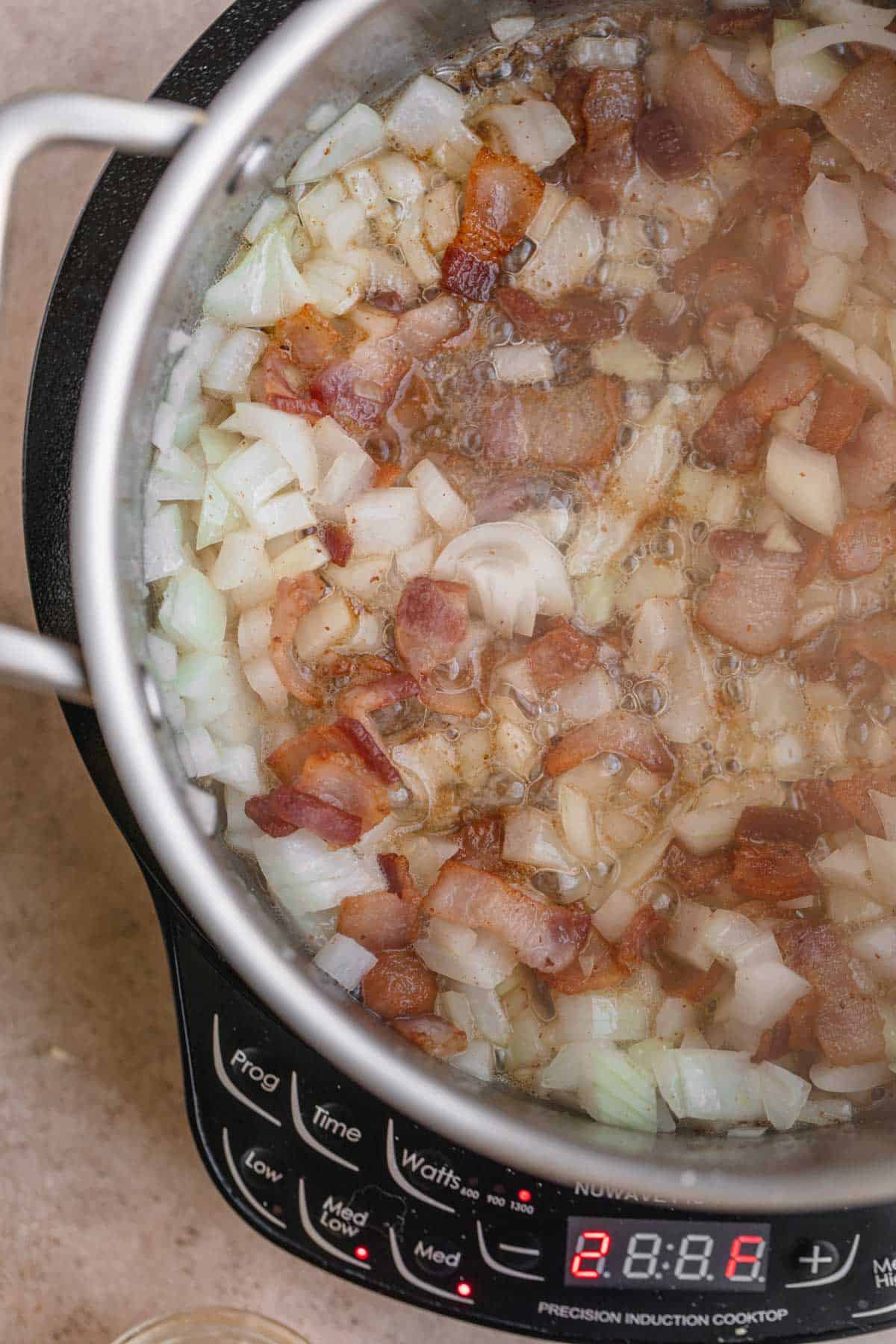 Cooked bacon with onions in a pot. 