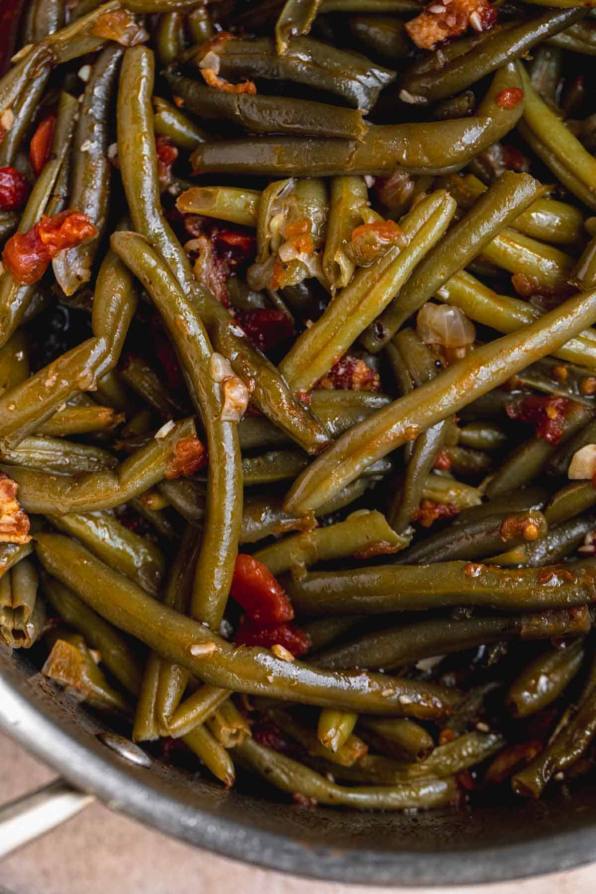 Cooked green beans with bacon in a pot. 