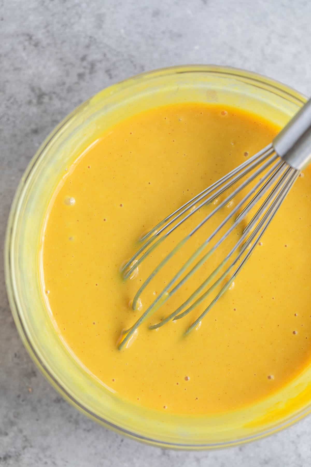 Honey Mustard Dressing ingredients whisked together in a bowl. 