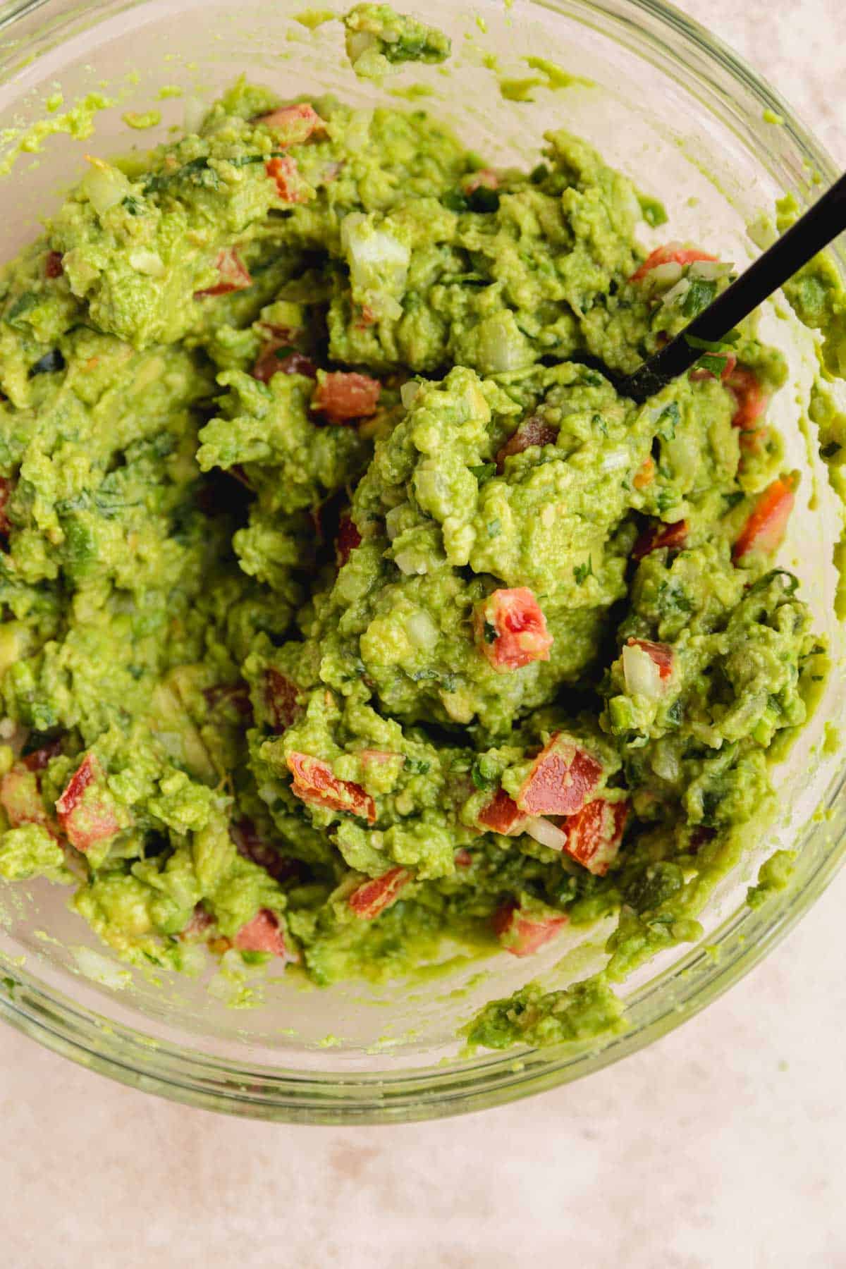 All guacamole ingredients mixed together in a bowl.