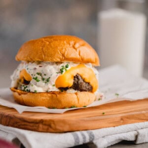 Truffle burger topped with Velveeta cheese and truffle aioli on a cutting board.