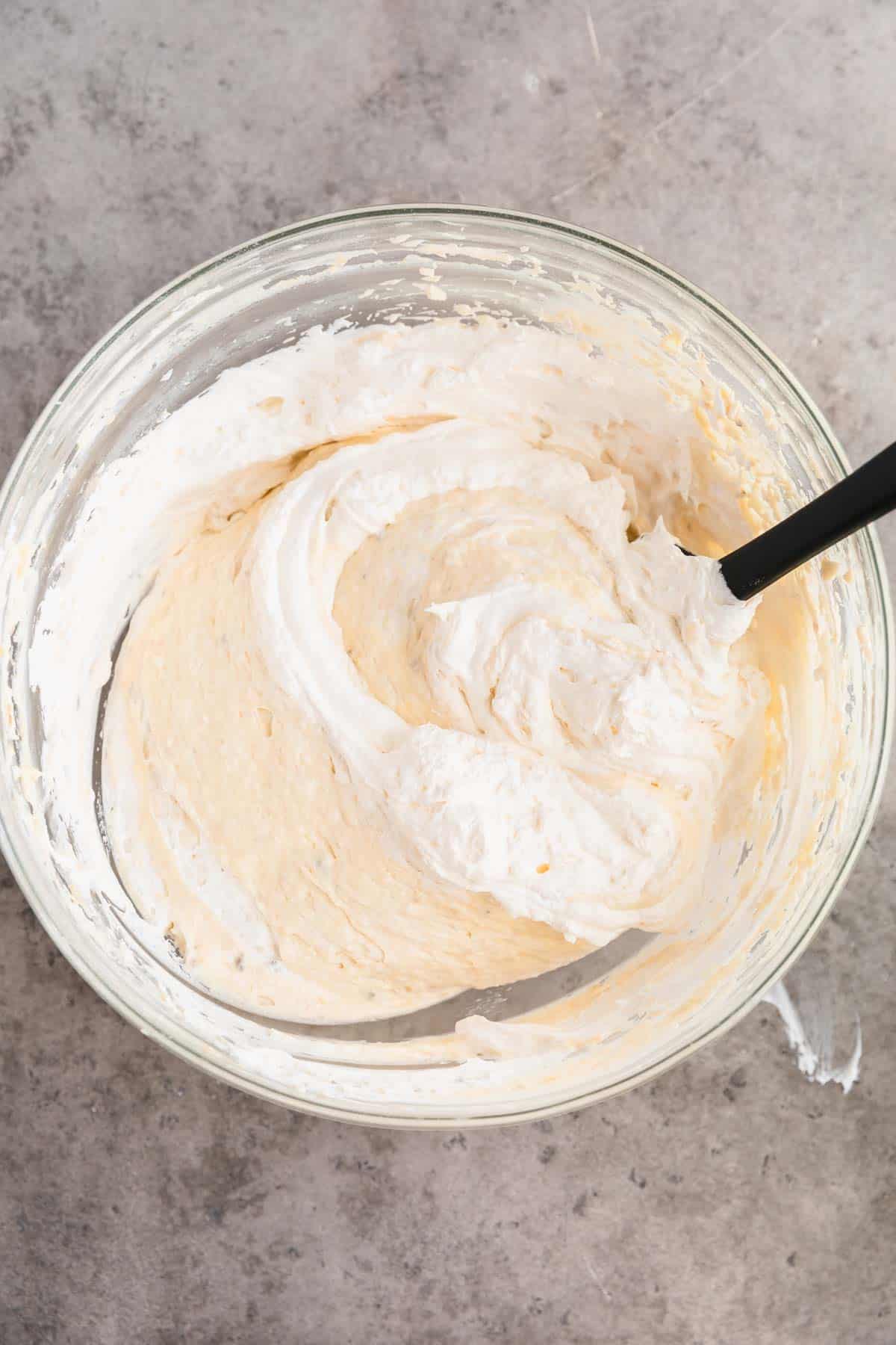 Cooked bananas and whipped cream added to banana pudding mixture. 