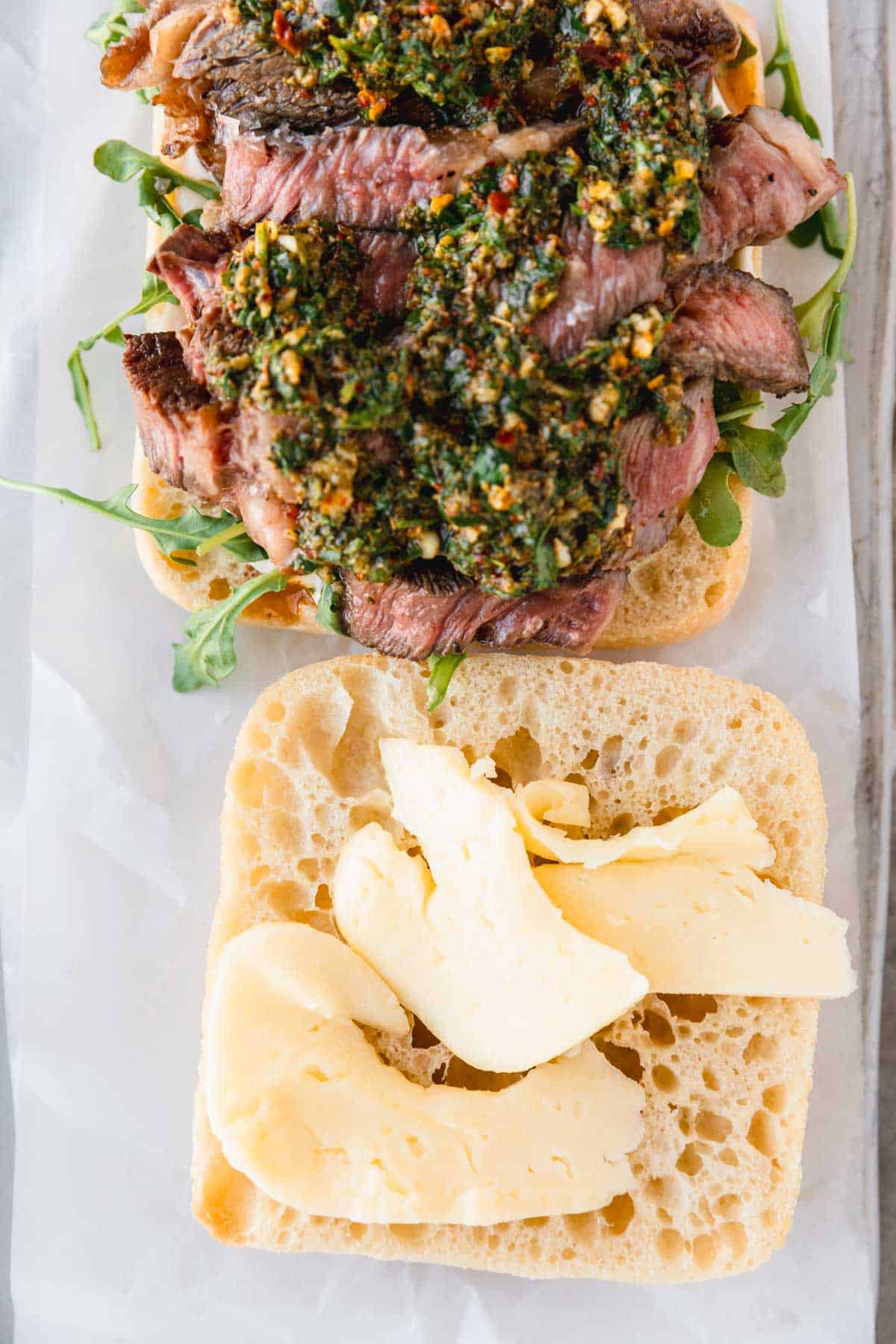 Chimichurri on top of steak on ciabatta bread. 