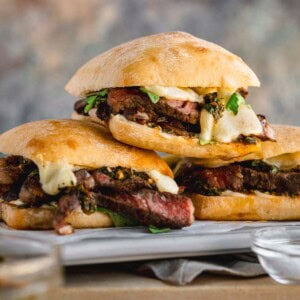 Ribeye Steak Sandwich topped with chimichurri, arugula and melted cheese.