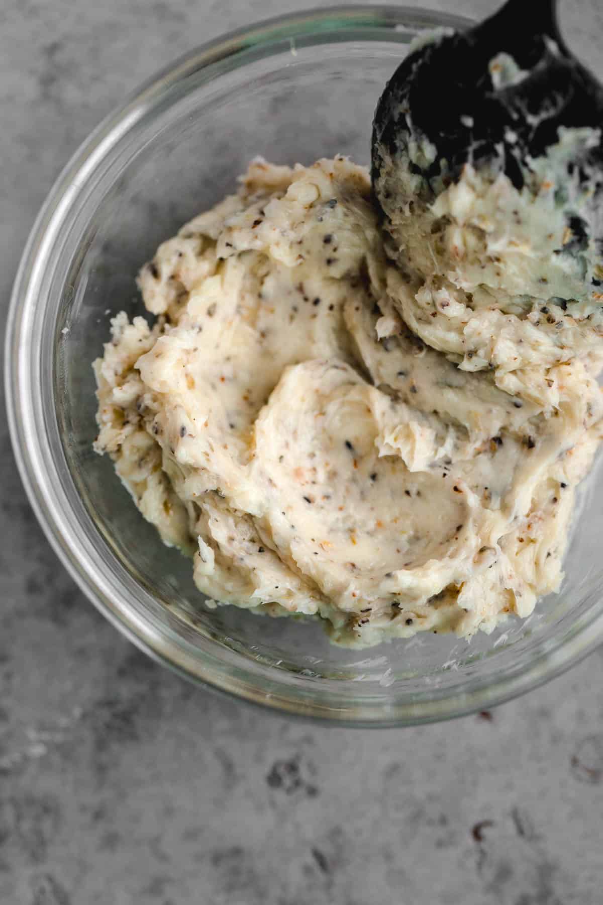 Compound butter in a small glass dish with a spoon.