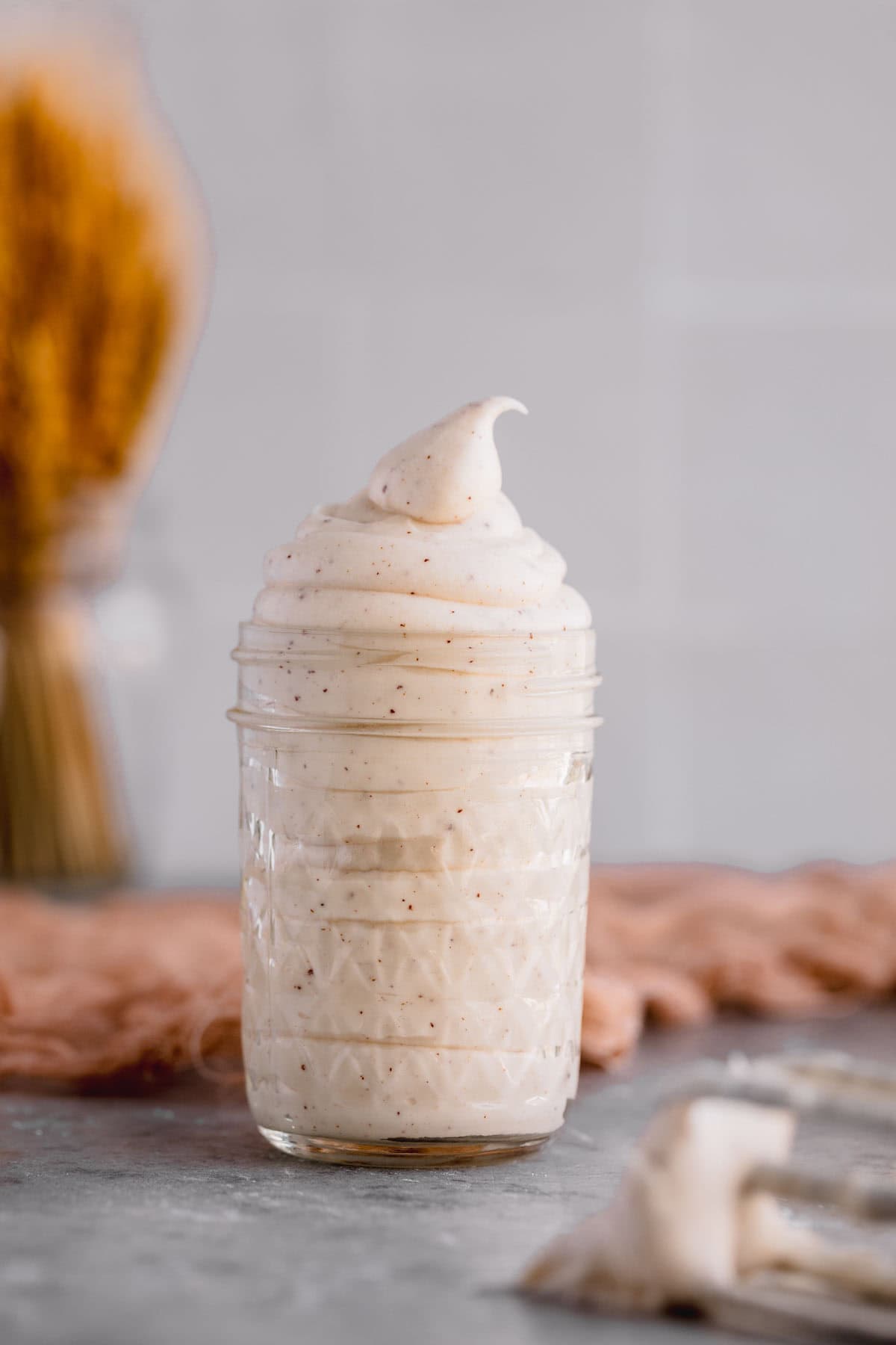 Brown butter cream cheese frosting in a glass jar. 