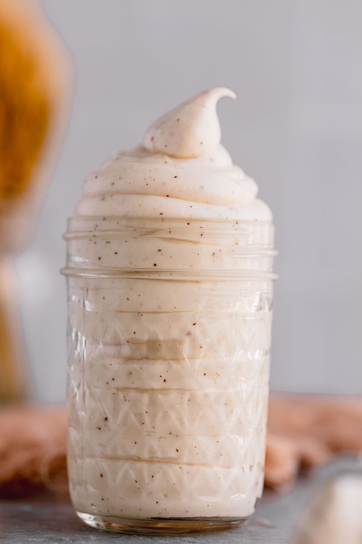 Brown butter cream cheese frosting in a glass jar. 