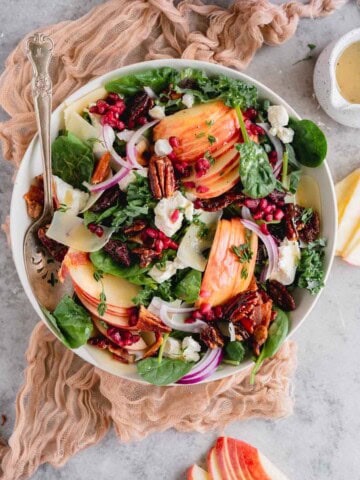 Kale Apple Salad with goat cheese, pomegranate seeds, red onions and vinaigrette.