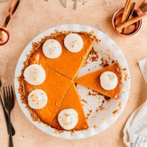 Pumpkin Pie with Graham Cracker crust in a pie dishes with a few slices removed.