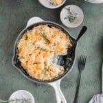 Cheesy Cauliflower Casserole in a skillet with a spoon.