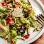 Shaved Brussel Sprout Salad with parmesan cheese on a plate with a fork.