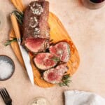 Reverse sear beef tenderloin sliced on a cutting board.