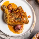 Coq au Vin Blanc on a plate with shallots.