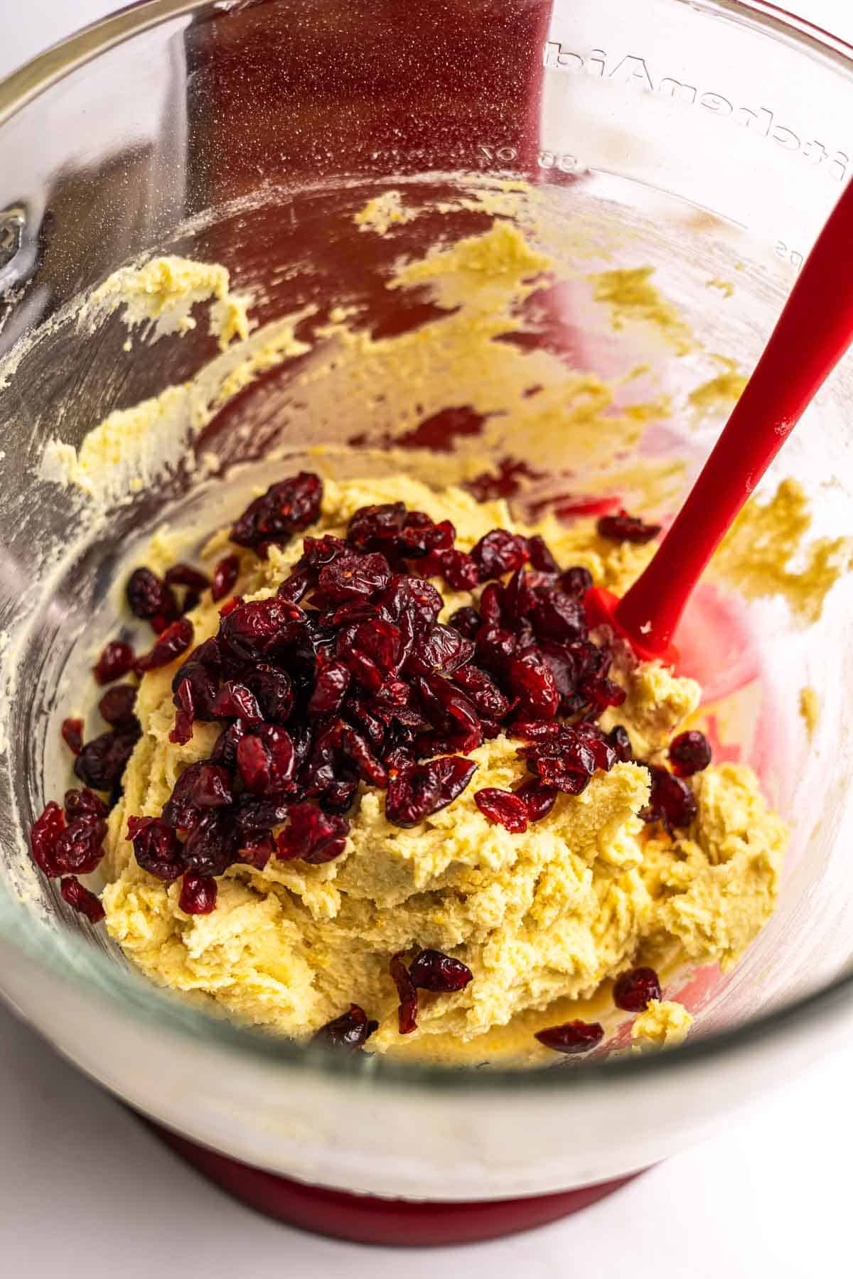 Cranberries being folded into shortbread cookie dough.