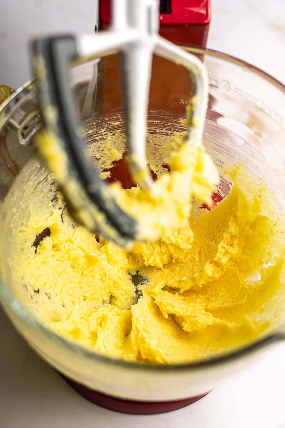 Butter creamed with sugar and orange zest in the bowl of a stand mixer. 
