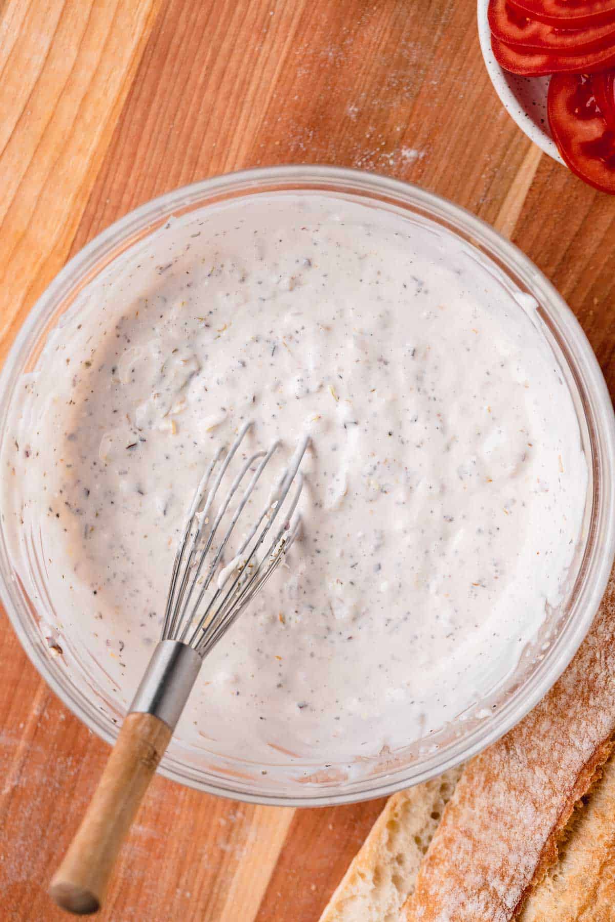 Salad dressing in a bowl with a whisk.