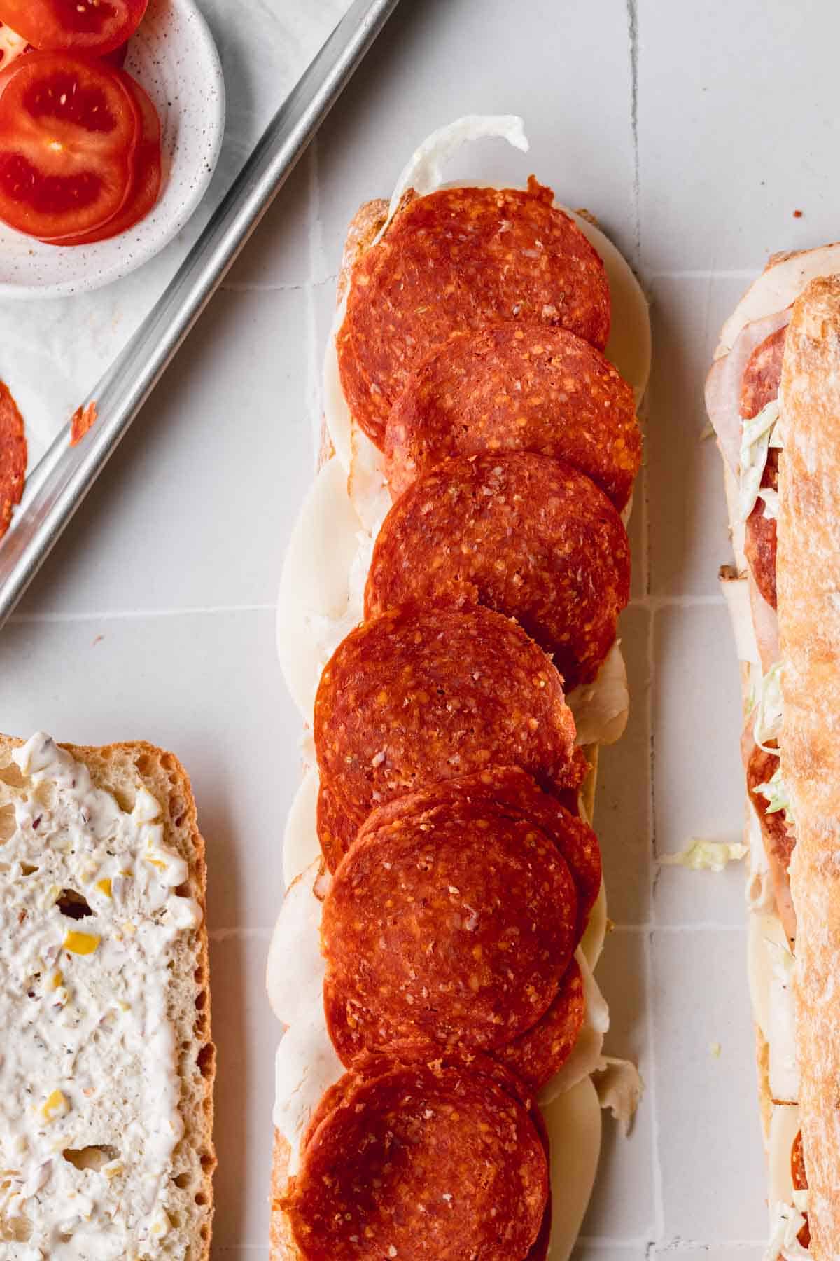 Grinder salad sandwich being put together. 