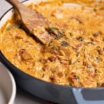 Marry Me Chicken Orzo in a pot with a wooden spoon.