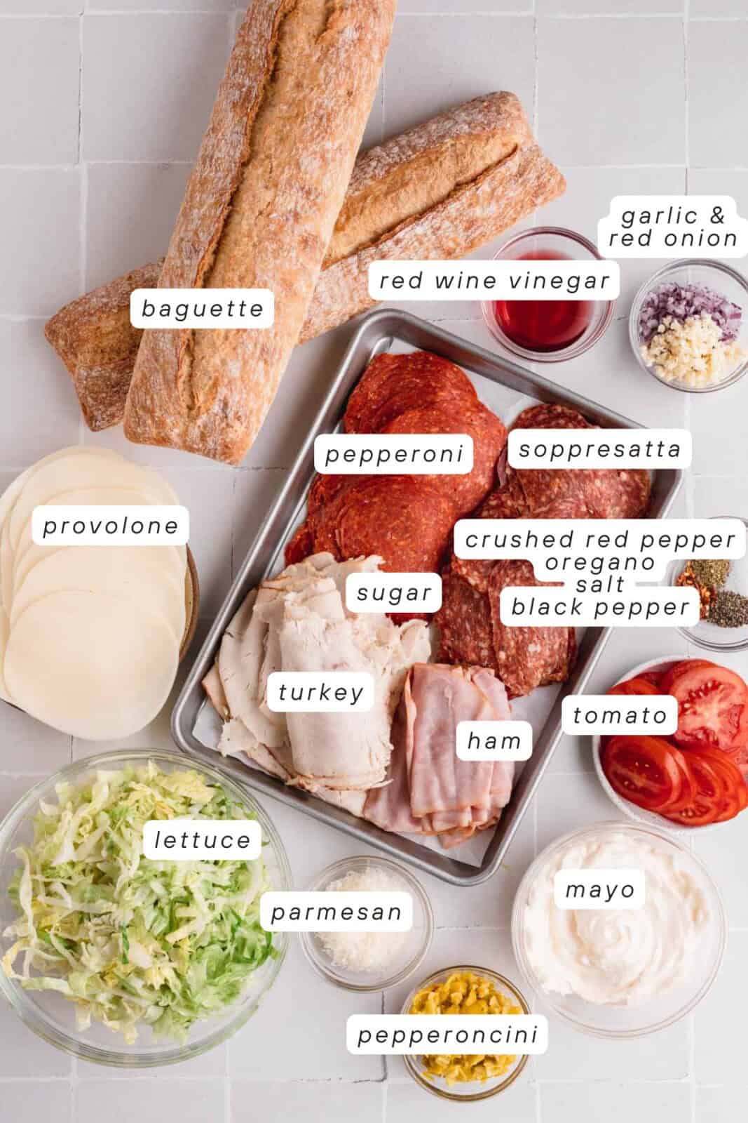 Baguette, red wine vinegar, garlic, pepperoni, soppresatta, ham, turkey, mayo, tomatoes, salt, pepper, crushed red pepper, oregano, pepperoncini, parmesan cheese, provolone and lettuce.