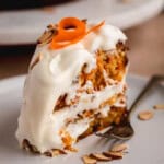A slice of carrot cake with a ton of cream cheese frosting.