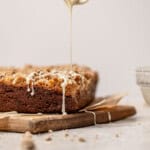 Banana Coffee Cake with maple glaze being drizzle over the top.