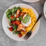 Chicken Shawarma Bowl with yellow basmati rice, veggies, tahini sauce and schug sauce.