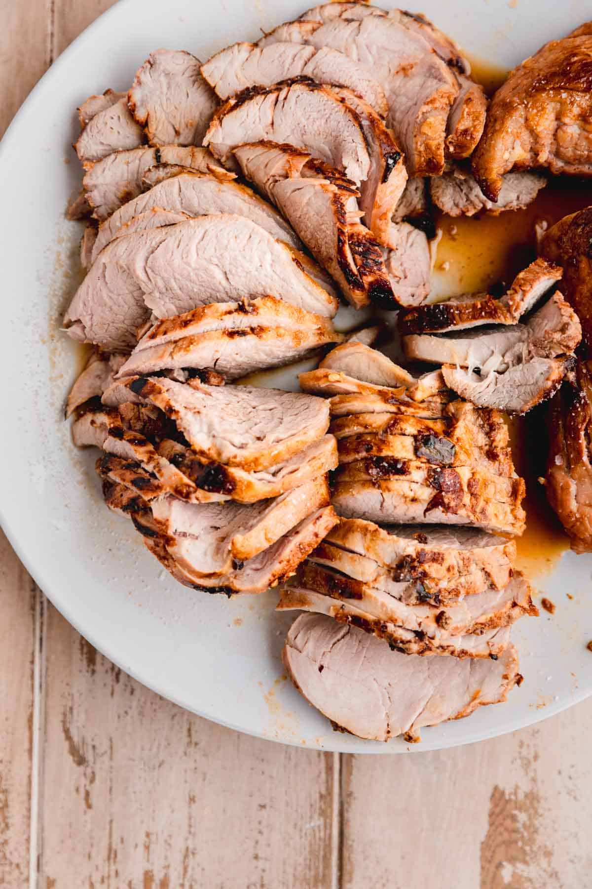 Seared and sliced pork tenderloin on a plate.