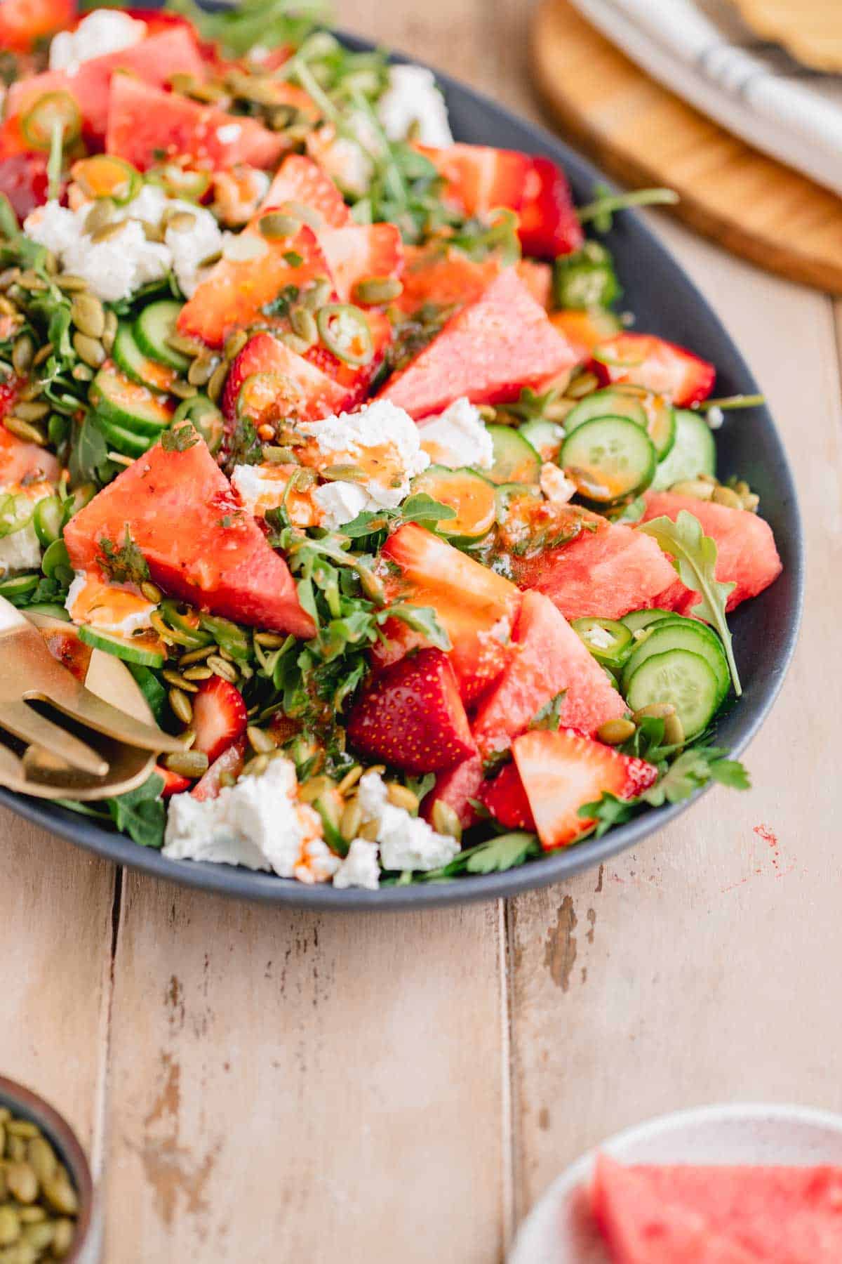 Spicy Watermelon Arugula Salad with Strawberry Chipotle Vinaigrette on top. 
