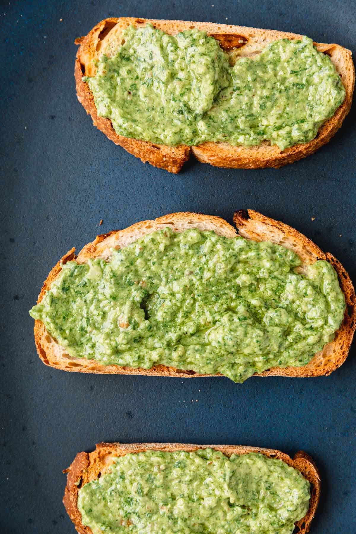 Pesto mixture spread onto toasted slices of rustic bread. 