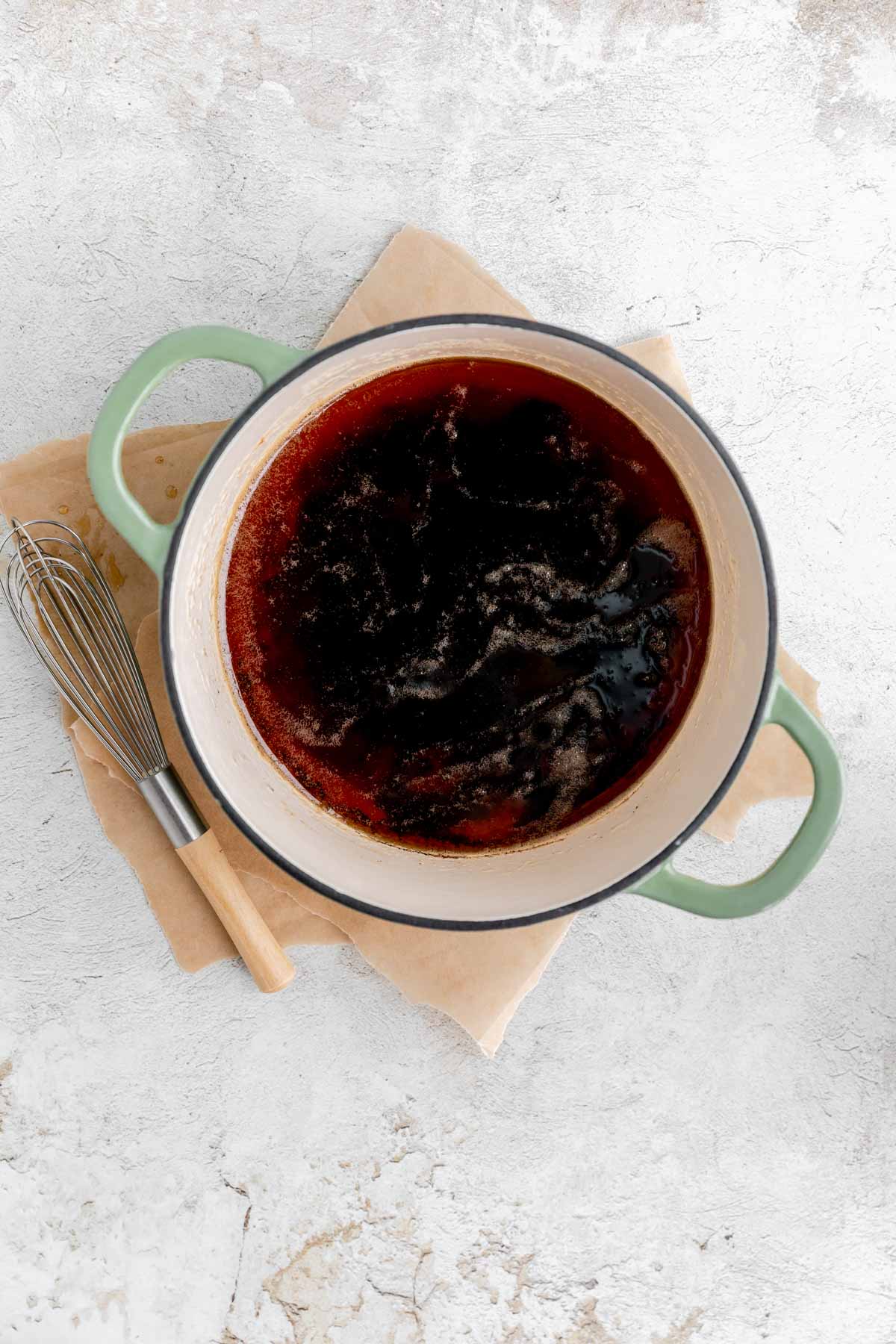 Brown butter in a pot with a whisk next to it. 