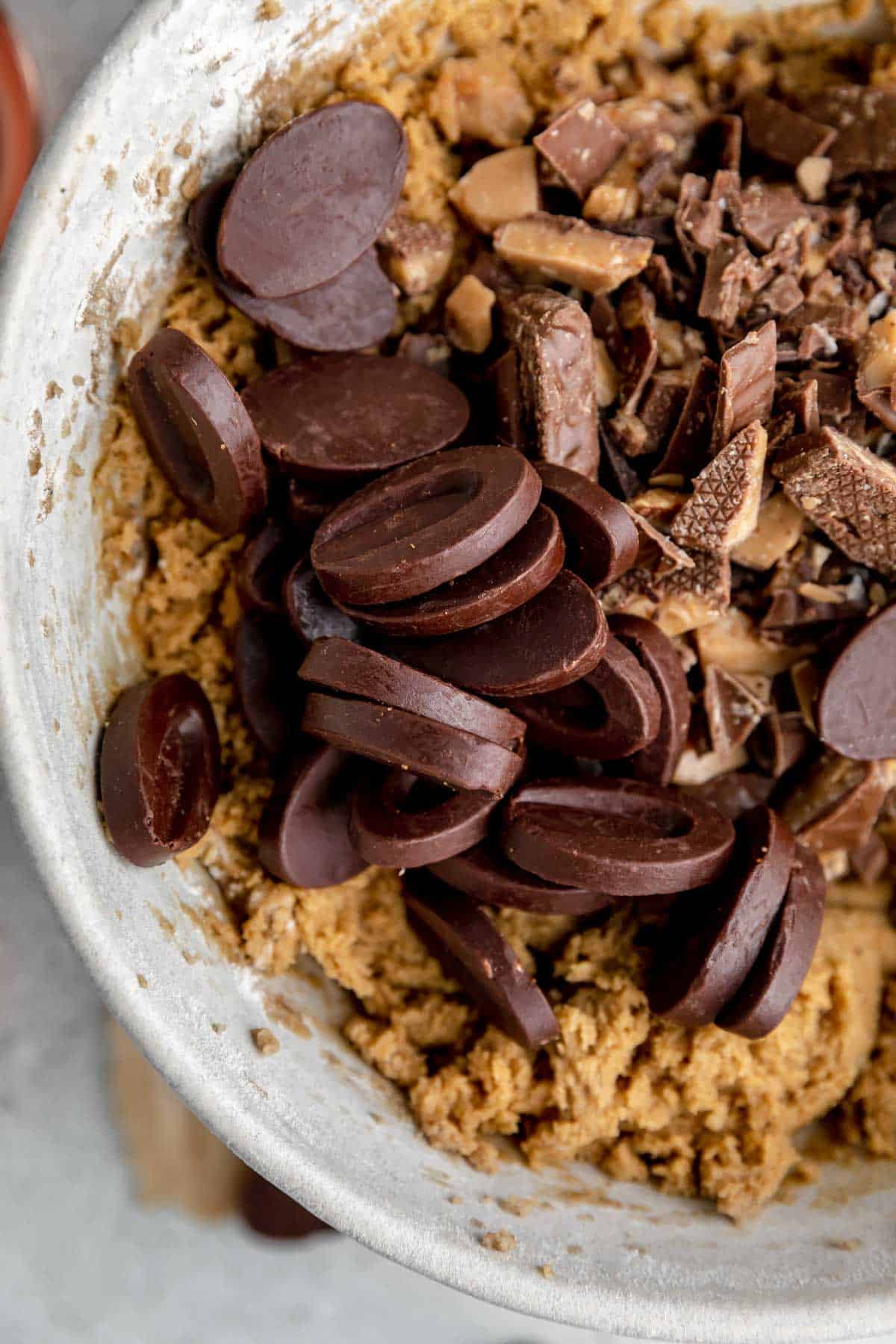 Chocolate and toffee in the bowl with cookie dough. 