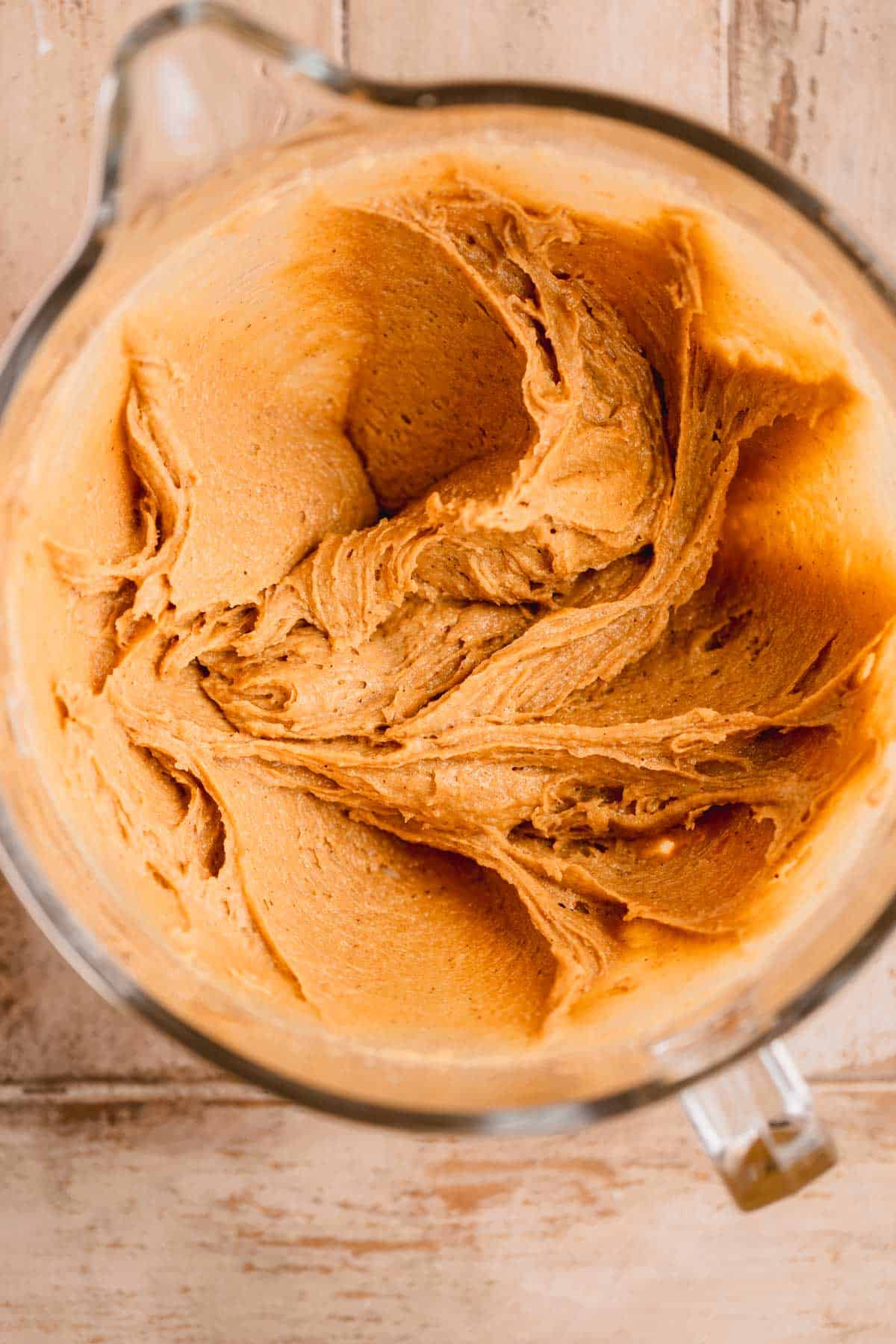 Peanut butter, egg and vanilla mixed in with the butter and sugars in the bowl of a stand mixer. 
