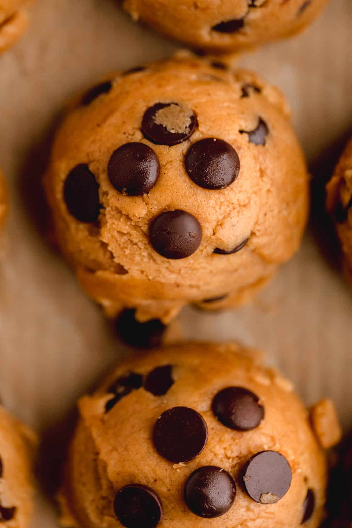 Chocolate Chip Peanut  Butter Cookie dough scooped onto a sheet tray lined with parchment paper. 