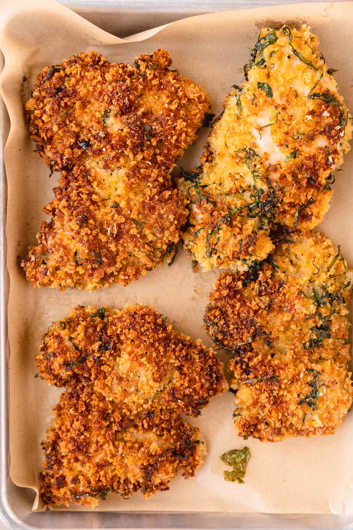 Pan fried chicken parmesan on a tray.