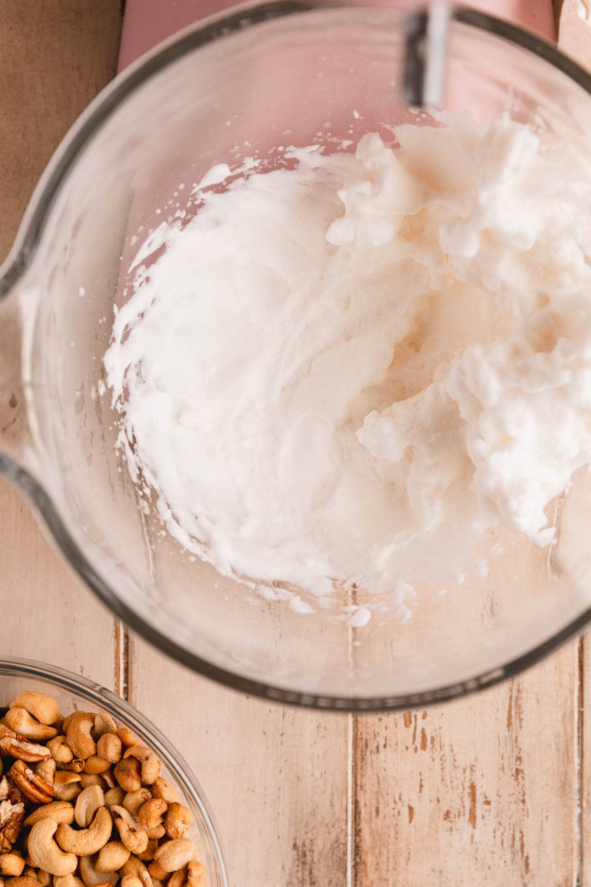 Egg whites whipped to a stiff peak in the bowl of a stand mixer. 