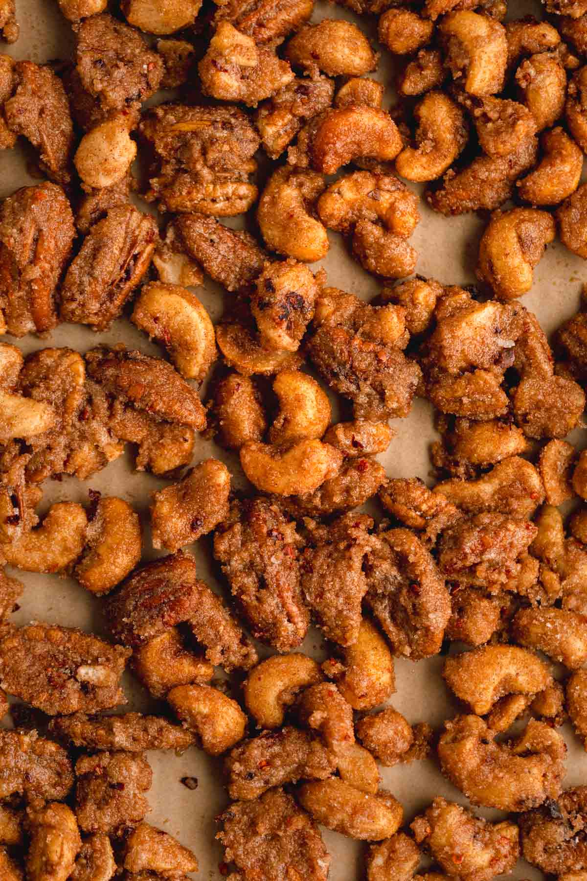 Holiday Candied Nuts with cashews and pecans on a sheet tray after being baked. 