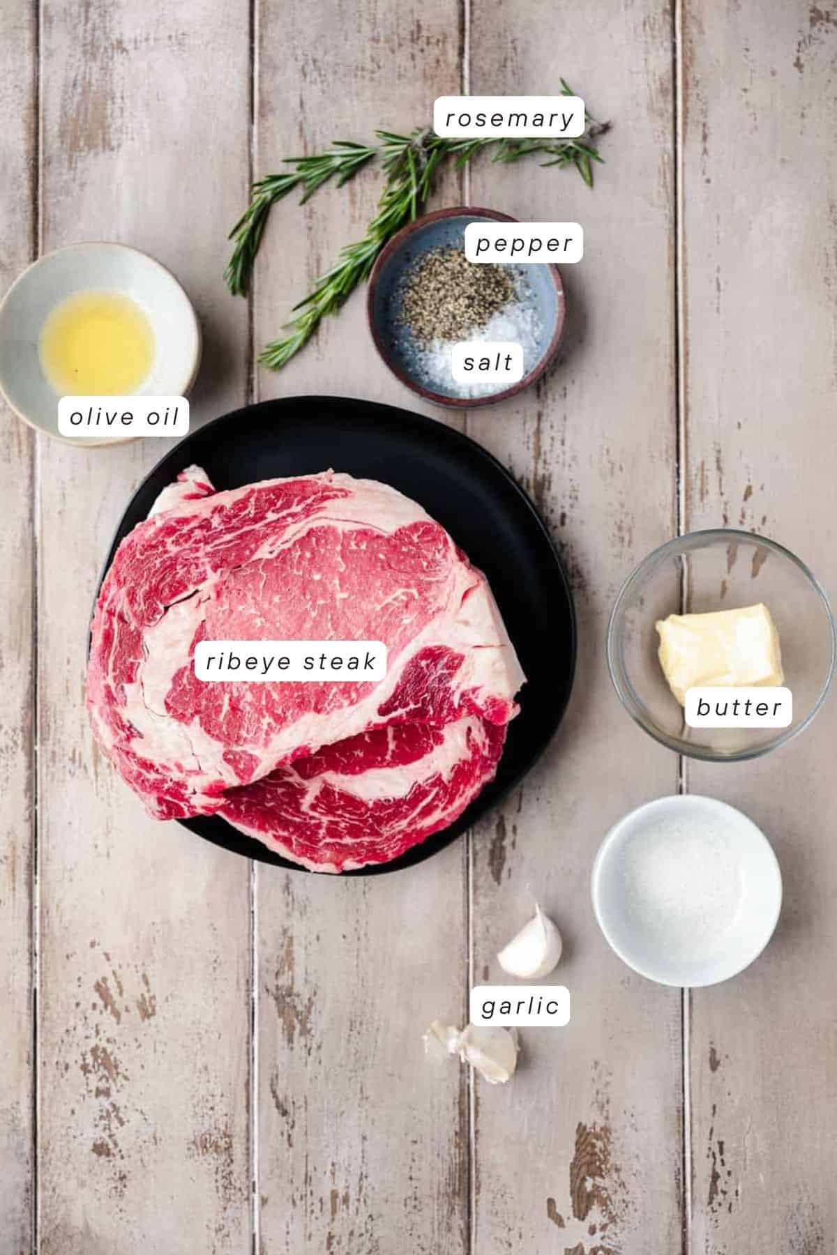 Ribeye steaks, olive oil, rosemary, salt, pepper, butter, and garlic.