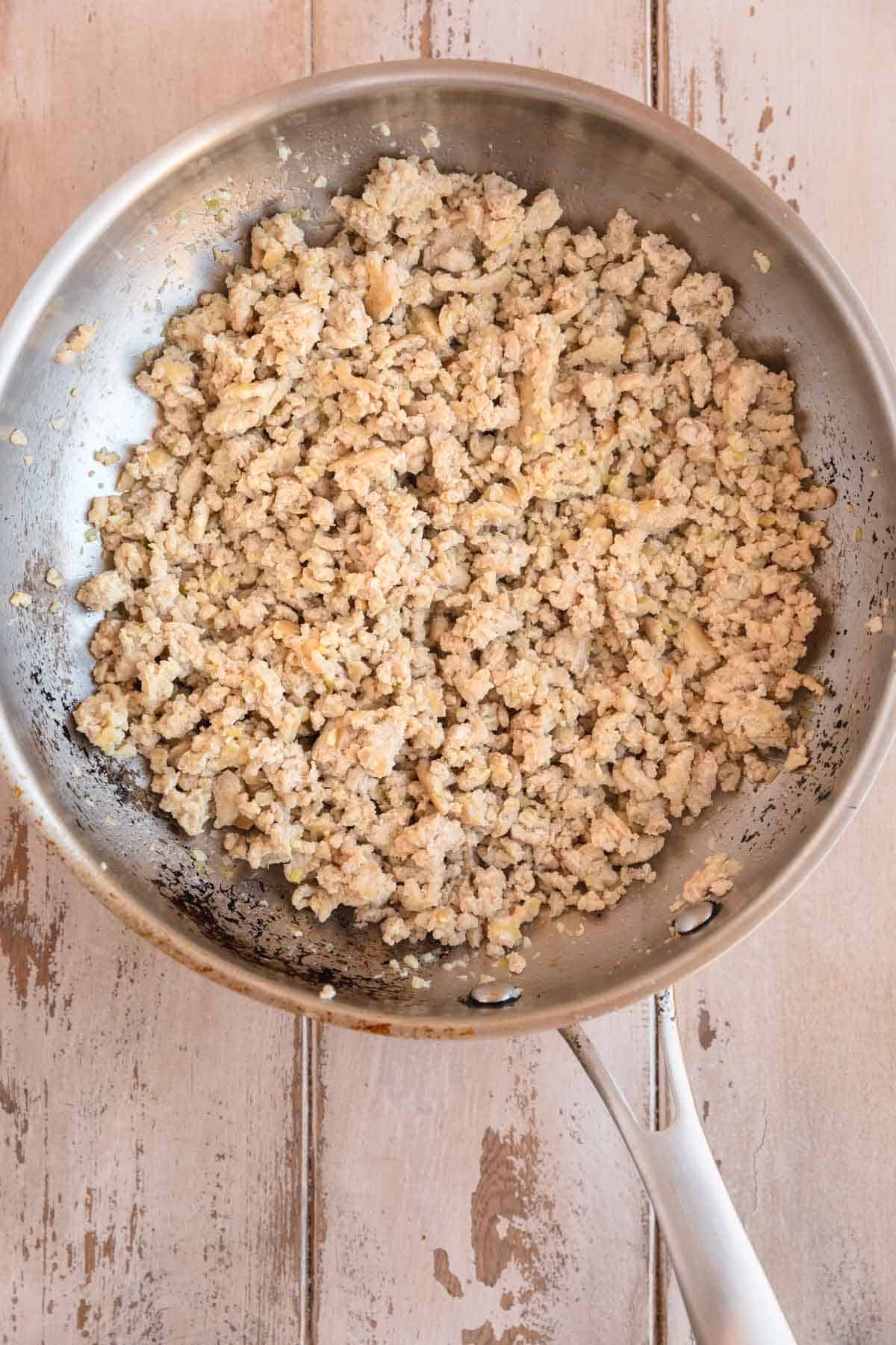 Ground chicken in a skillet.