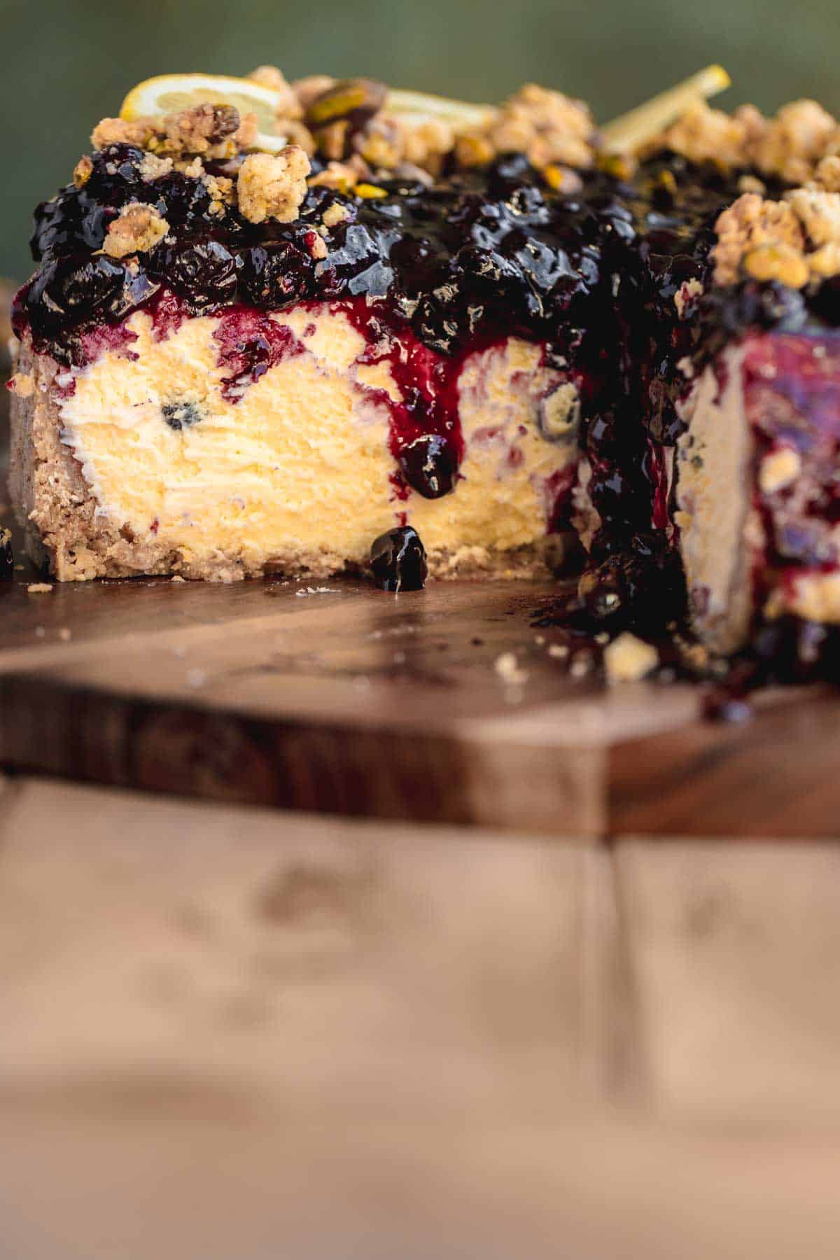 Lemon Blueberry Cheesecake with a slice taken out to see the center. 